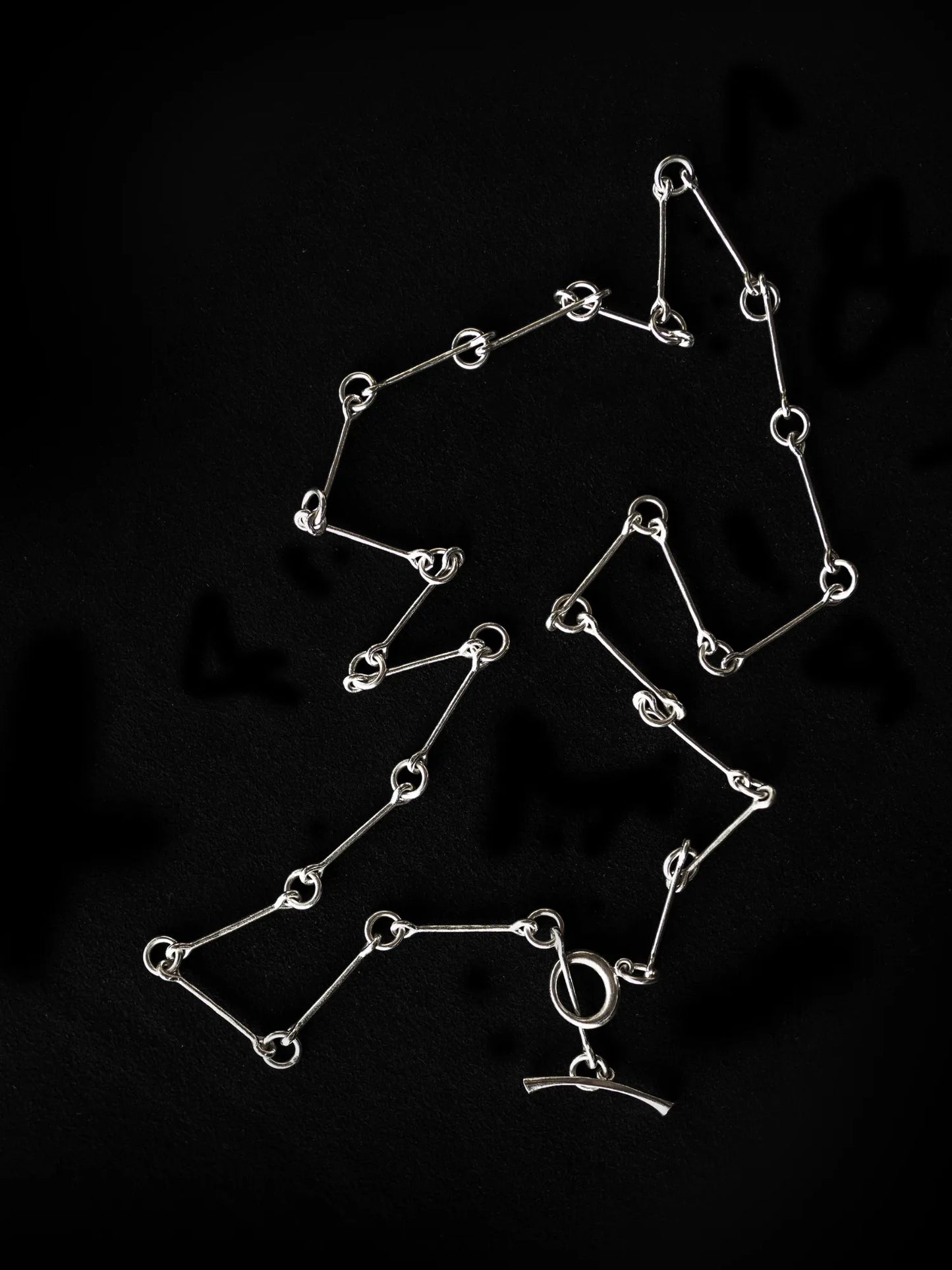 Maancy silver chain necklace artisan-made in Los Angeles studio, arranged to showcase the flowing infinity link pattern.