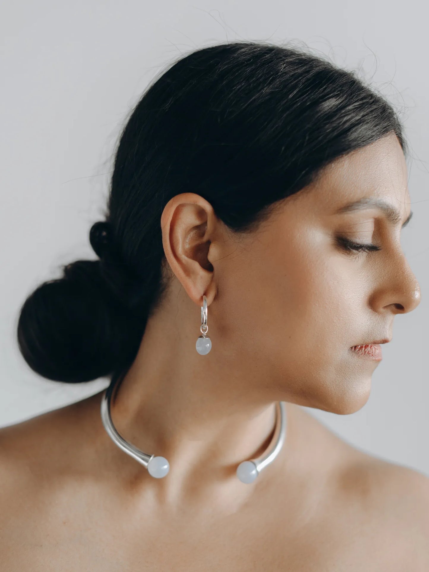 Model wearing Maancy sterling silver interchangeable jewelry set with chalcedony stones, featuring collar necklace and matching drop earrings.