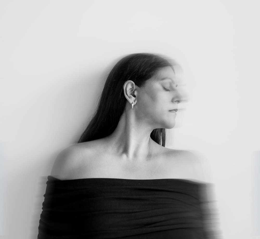 Model wearing Maancy Day and Night reversible chalcedony hoop earrings in sterling silver, showcasing the elegant profile and versatile design.