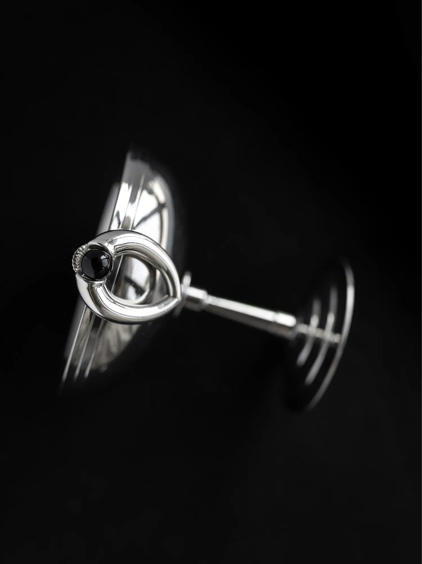 Close-up detail of Maancy sterling silver teardrop earring showing post and onyx stone setting, demonstrating secure attachment system.