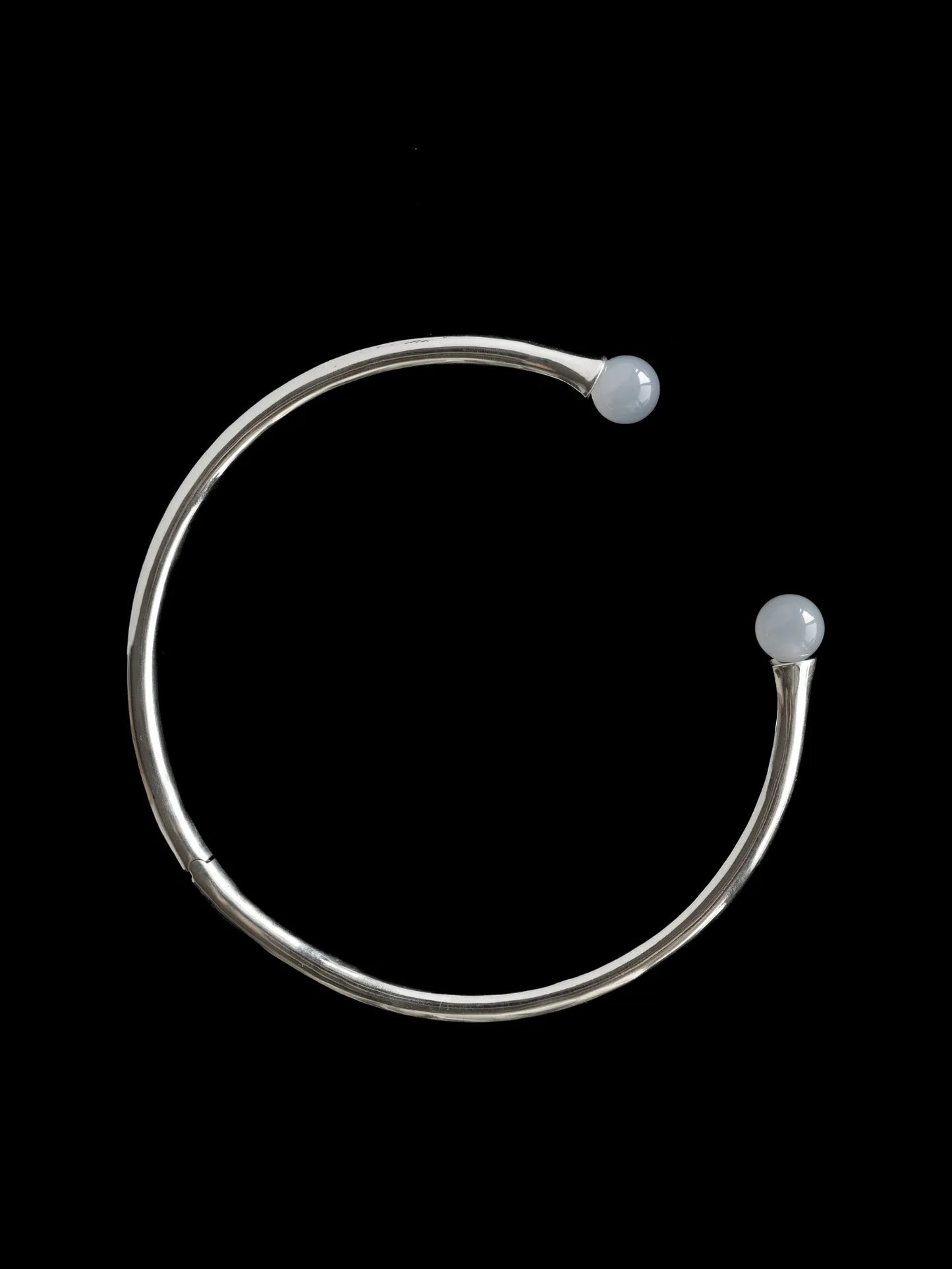 Maancy sterling silver convertible collar necklace with luminous chalcedony spheres, showcasing minimalist circular design on black background.