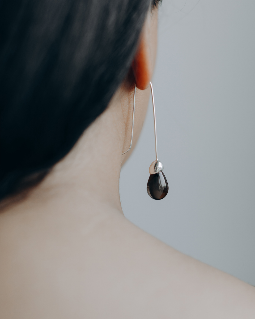 Close-up of model wearing Maancy goutte silver drop earrings with smoky quartz gemstone, showcasing the elegant profile and contemporary design.