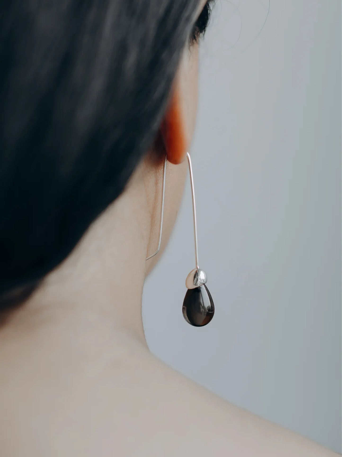 Side profile of model wearing Maancy Goutte earring with smoky quartz teardrop gemstone, showcasing elegant length and movement.