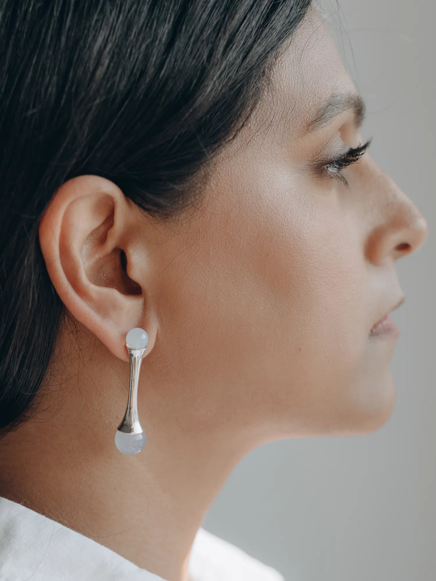 Side profile of model wearing Maancy handcrafted silver earrings with chalcedony stones, showcasing the elegant silhouette and wearability.