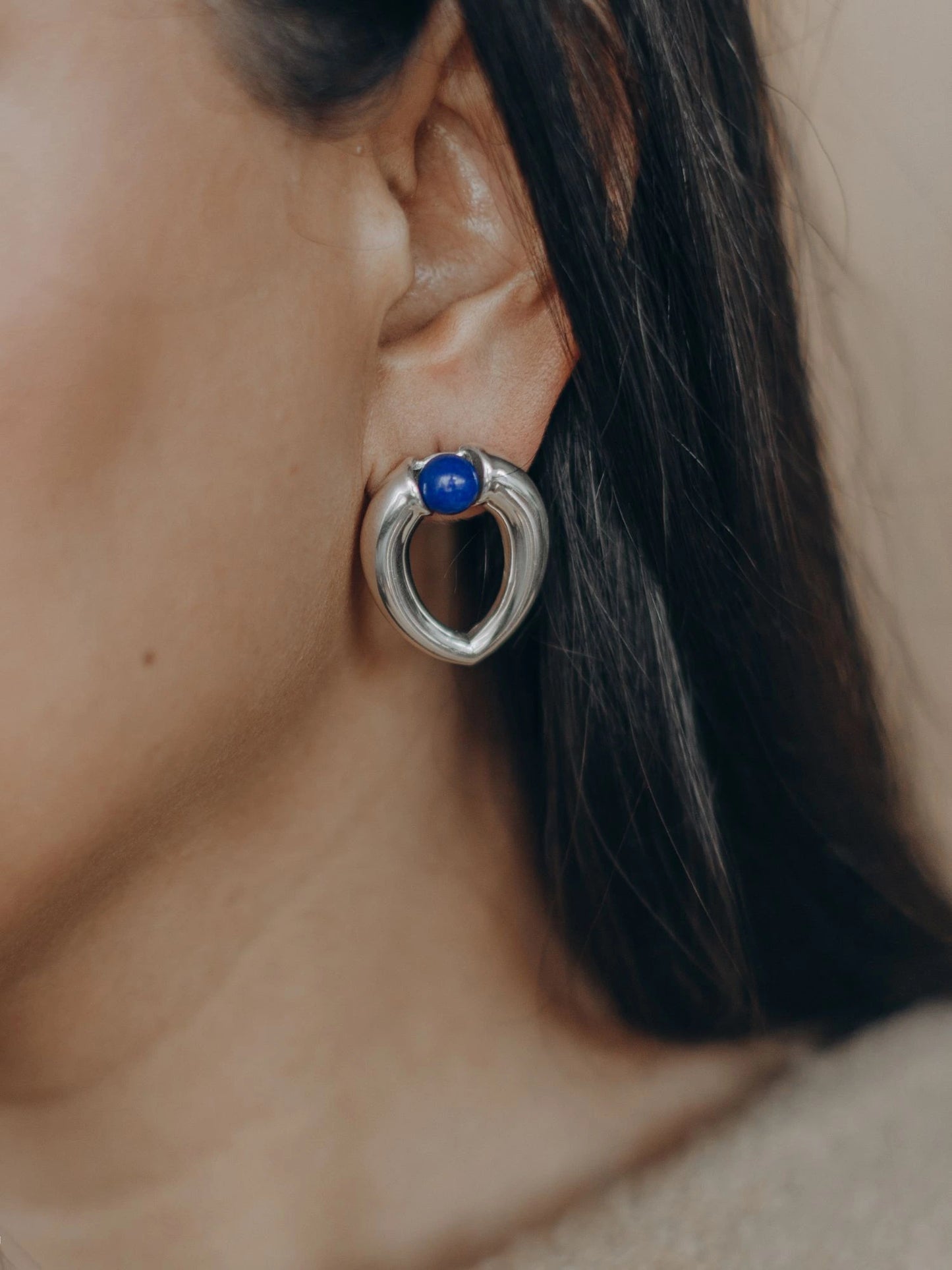 Model wearing Maancy interchangeable teardrop earring in sterling silver with lapis lazuli gemstone, showcasing the modernist design with versatile styling.