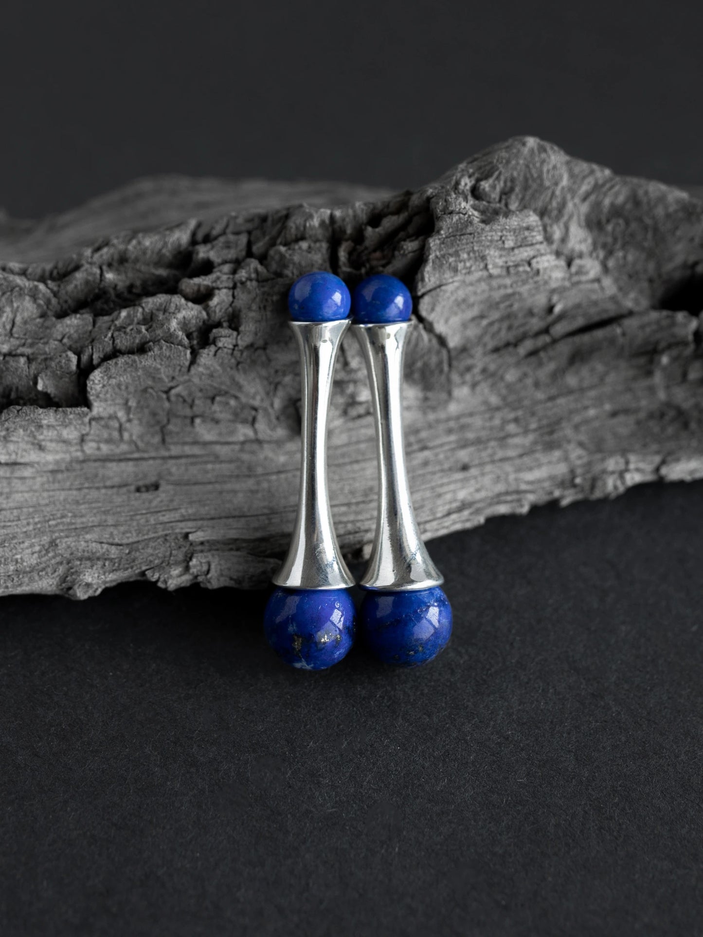 Maancy interchangeable lapis lazuli fluted earrings in sterling silver, displayed on textured driftwood. Natural gemstone studs designed for versatile modular styling.