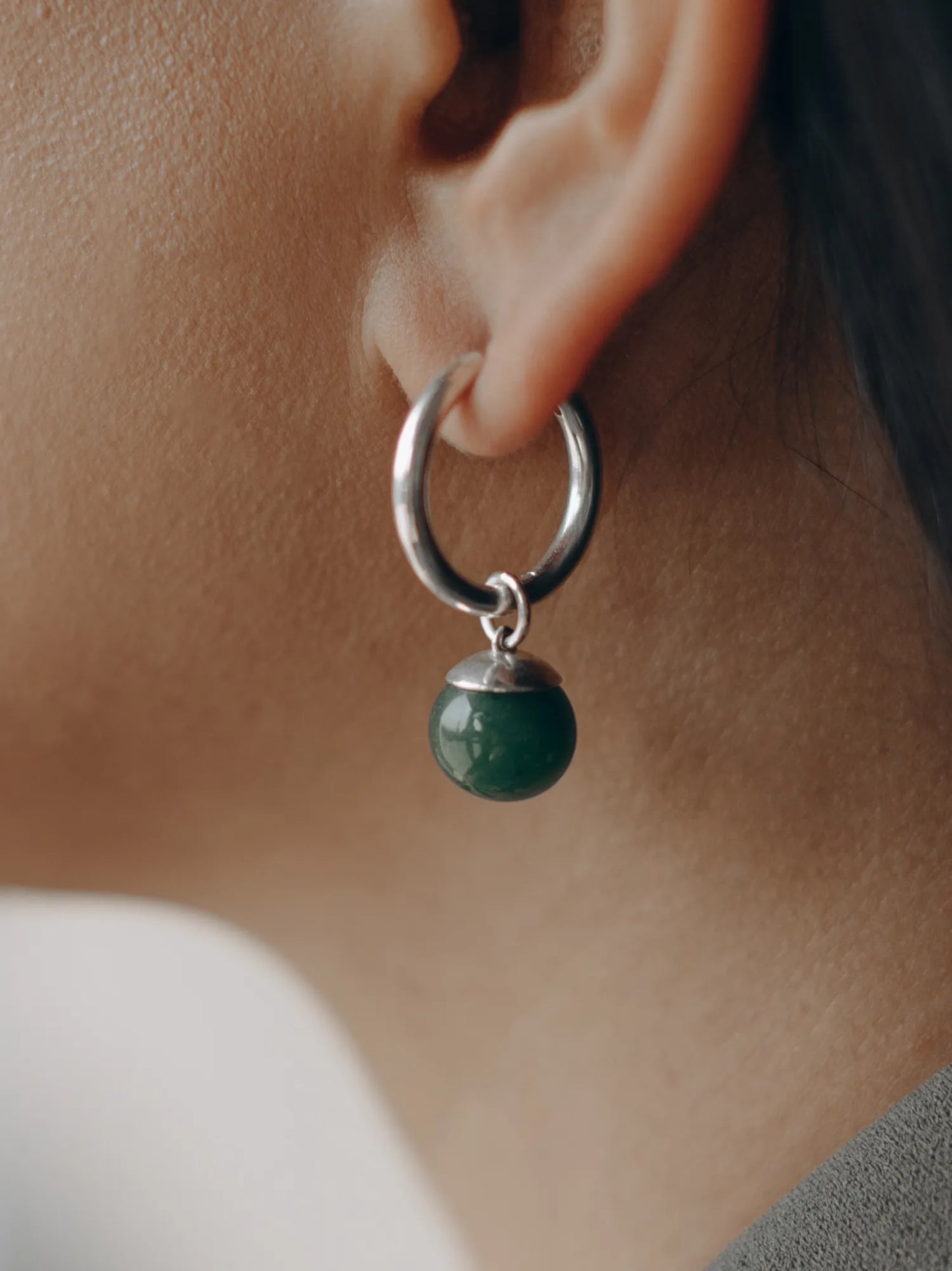 Side view of model wearing Maancy convertible hoop earrings with vibrant green jade drop, highlighting the versatile everyday design.