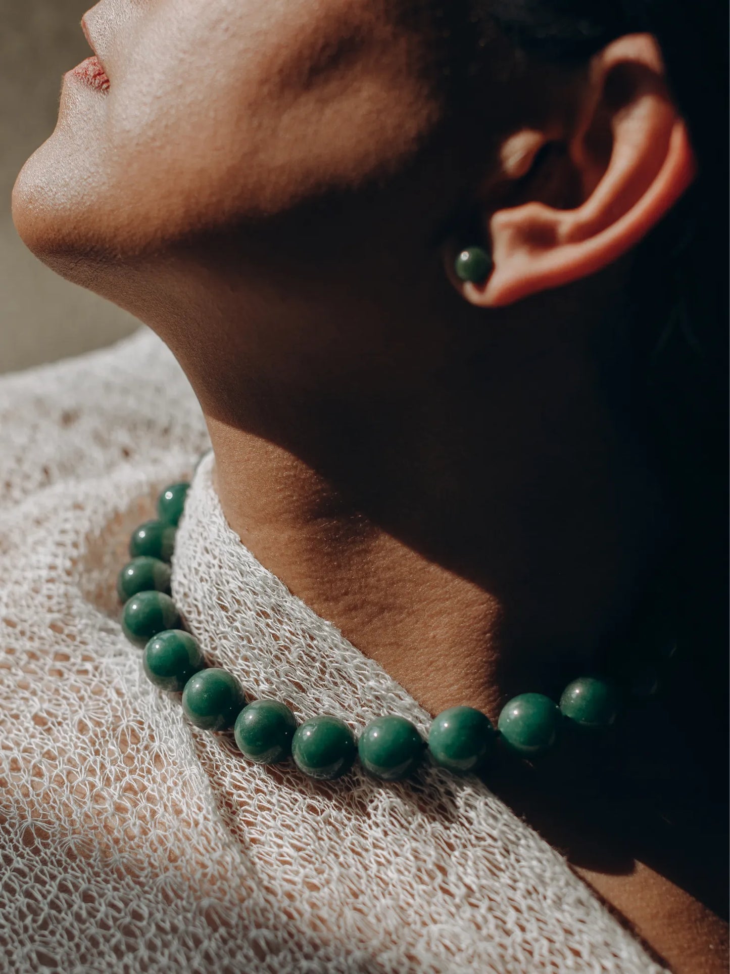 Model wearing Maancy jade Orb Collar necklace in profile view, showing how the 16mm green spheres sit perfectly at the collarbone.