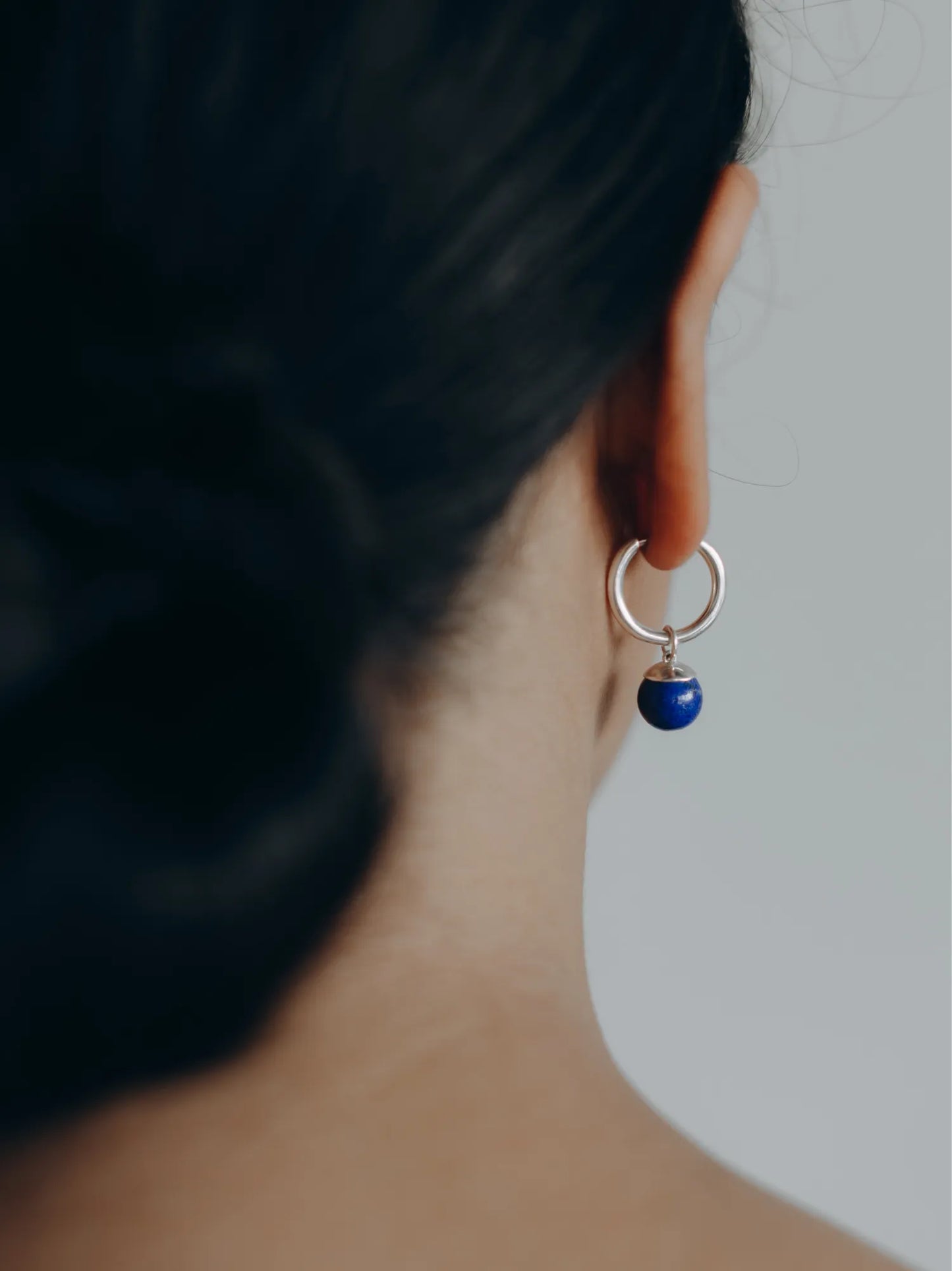 Elegant profile view of model wearing Maancy interchangeable lapis hoop earrings, demonstrating the perfect proportions and lightweight comfort.