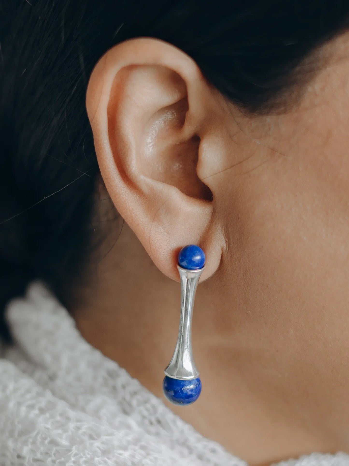 Model wearing Maancy sterling silver earrings with lapis lazuli gemstones, showing the elegant drop design against skin.
