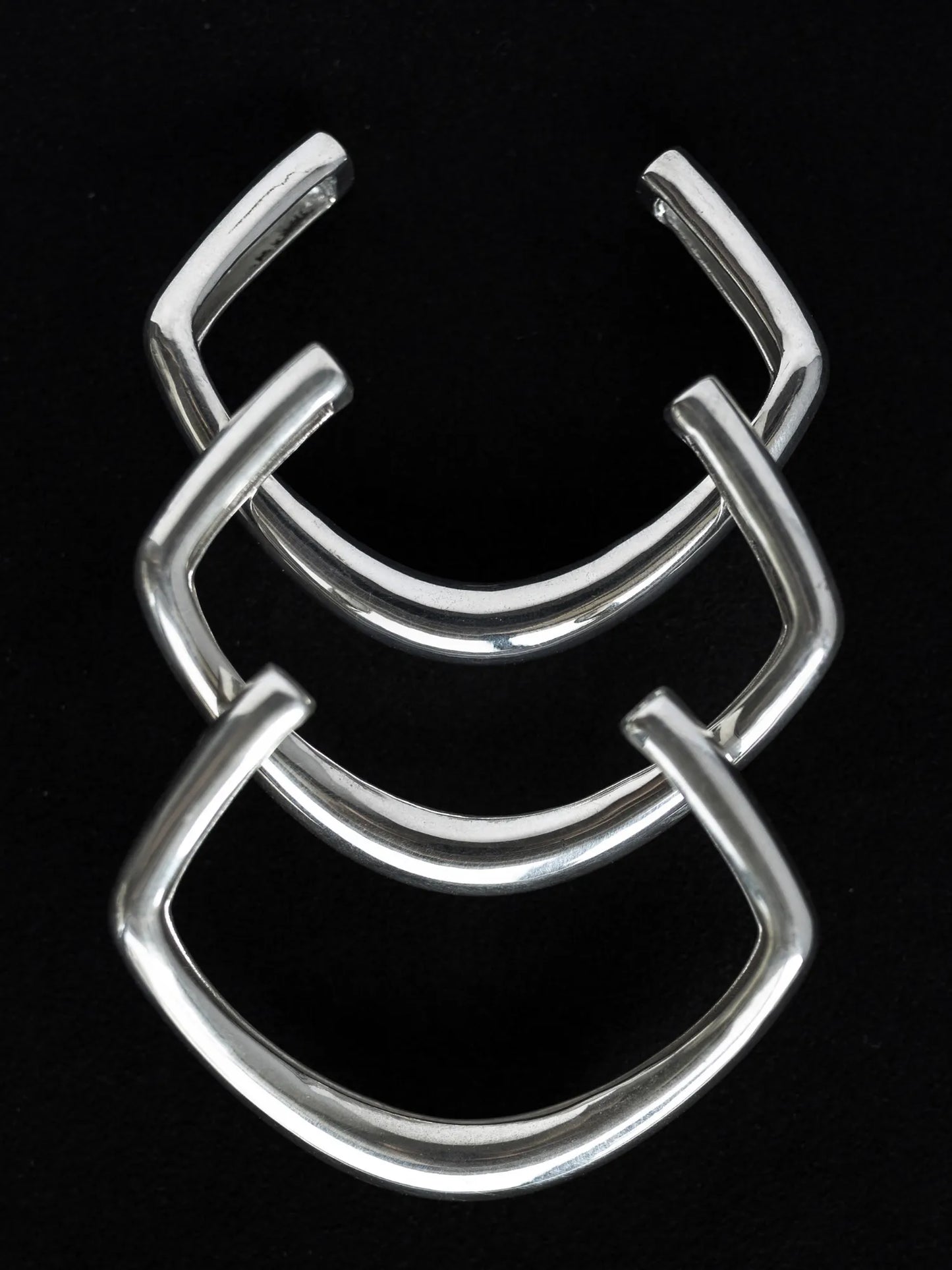 Maancy modernist sterling silver bangle set displaying three stacked sculptural pieces with 60mm diameter and architectural angular form.