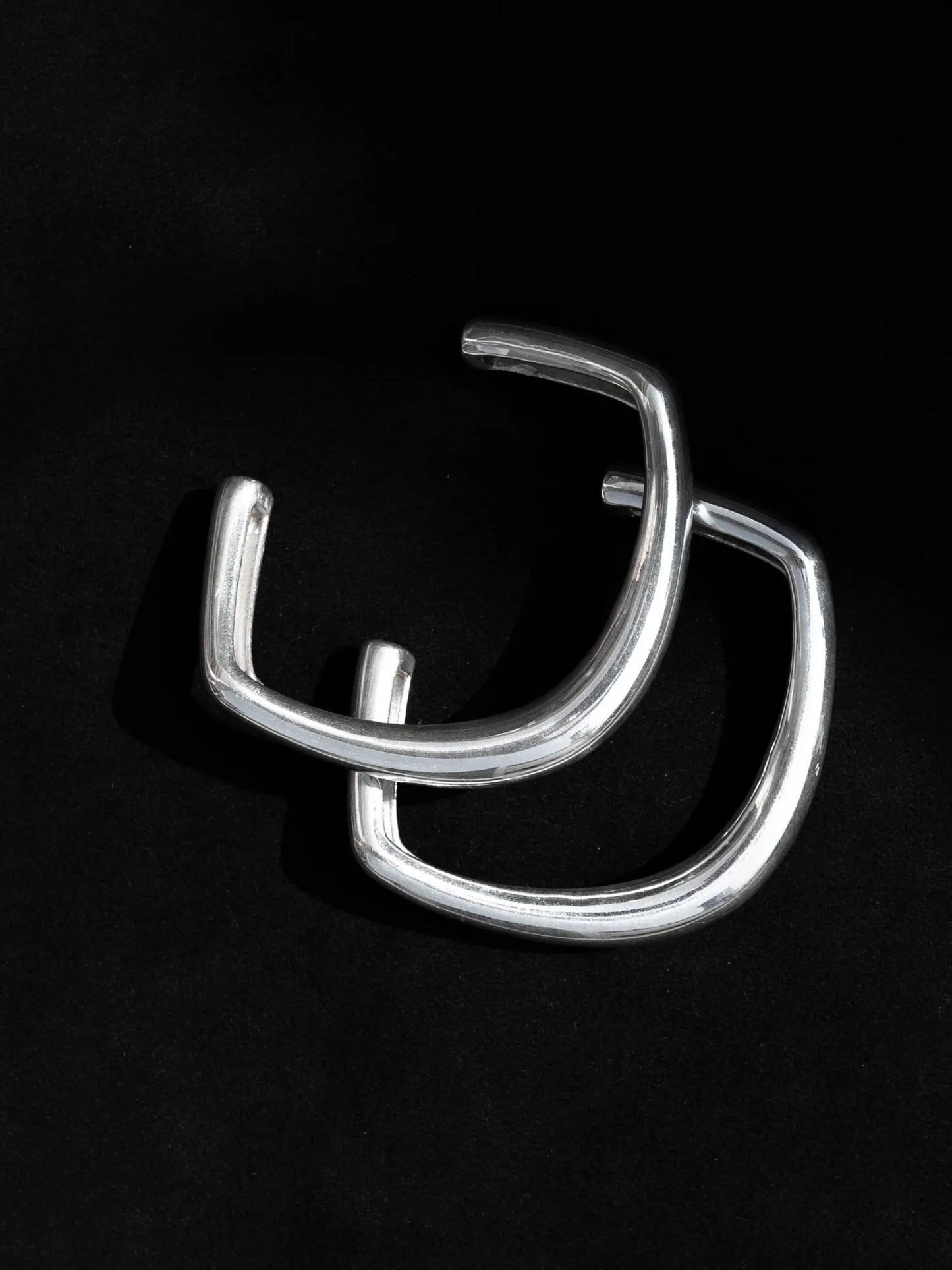 Maancy oblique silver bangle pair showcasing geometric angular design, handcrafted in sterling silver with clean modernist lines.