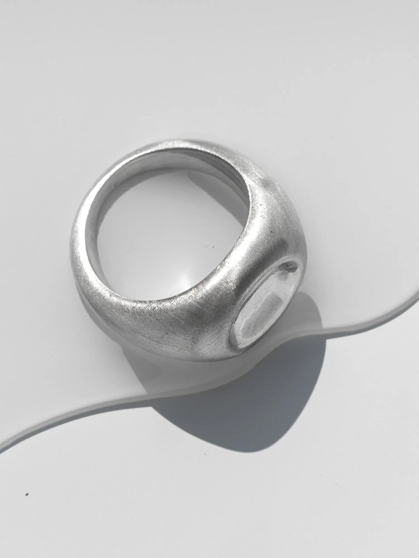 Maancy sterling silver statement ring with mirror dome center shown from above on light background, showcasing the satin finish band and polished center.