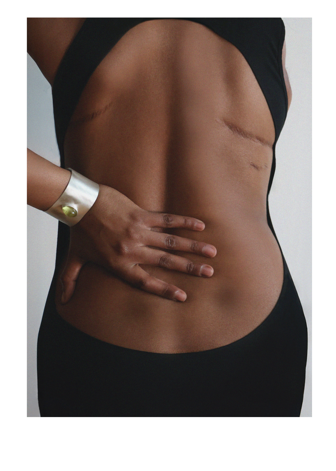 One handed over dressed model Maya Moore wearing structural silver cuff bangle with lemon quartz gemstone