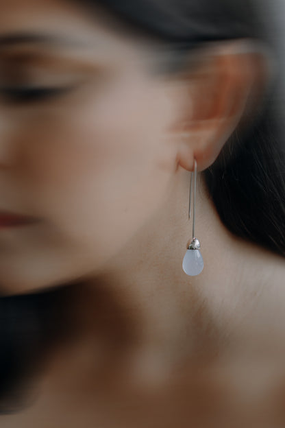 Model wearing Maancy Goutte sterling silver earring with chalcedony teardrop, showing elegant profile view of the contemporary jewelry design.