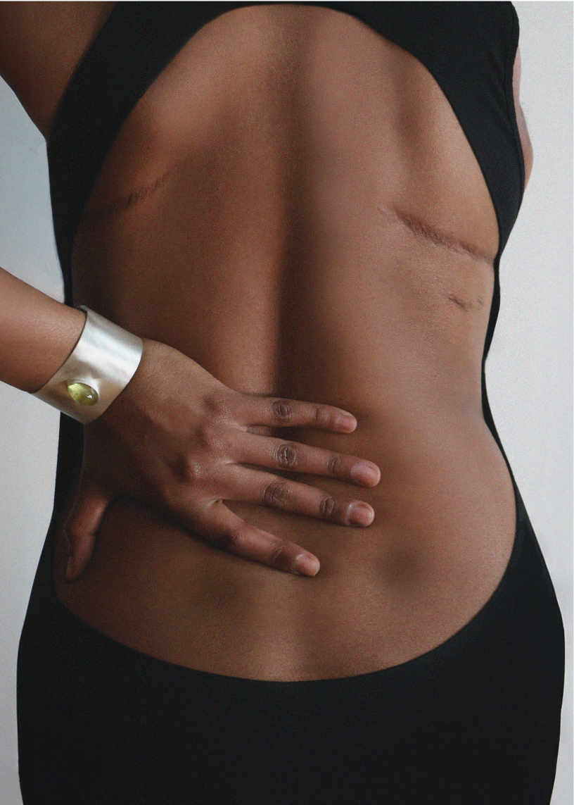 One handed over dressed model Maya Moore wearing structural silver cuff bangle with lemon quartz gemstone