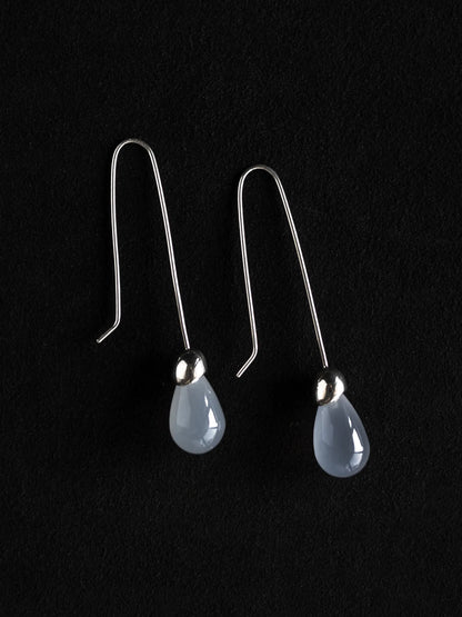 Maancy Goutte sterling silver drop earrings with translucent chalcedony teardrop gemstones on black background, showcasing minimalist design.