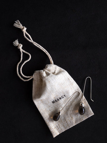 Maancy Goutte smoky quartz drop earrings with eco-friendly cotton packaging bag, highlighting sustainable jewelry presentation.