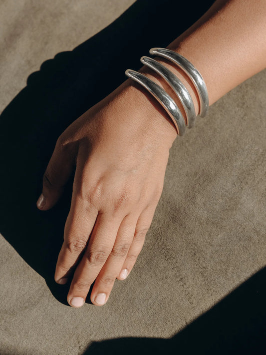 Maancy handcrafted silver bracelet trio worn on wrist against neutral background, demonstrating the oblique design's versatile wear comfort.