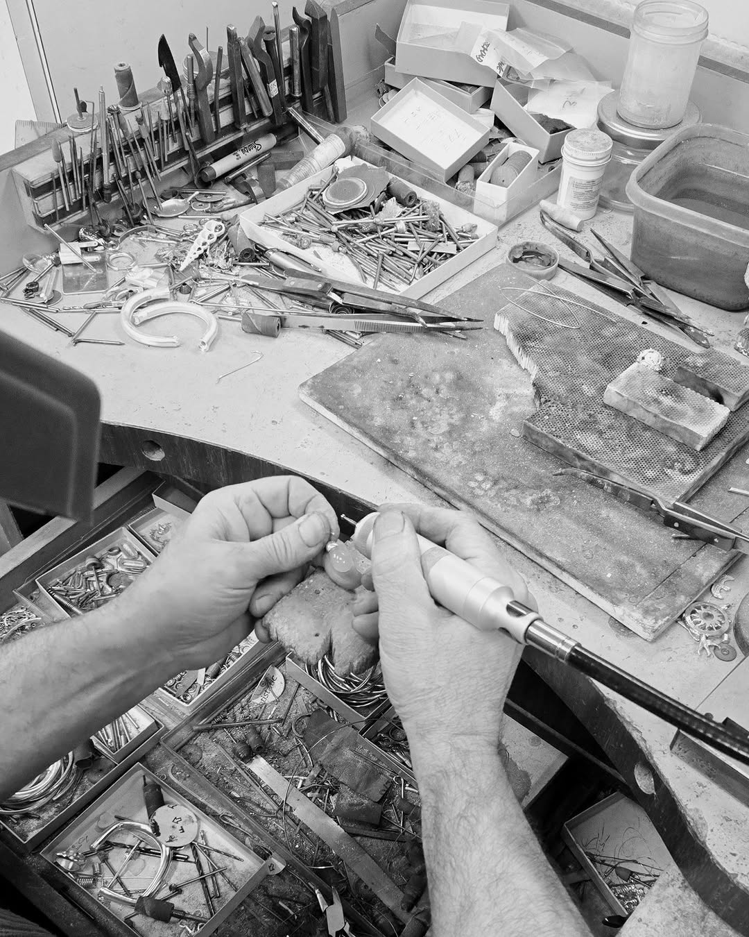Artisan hands crafting Maancy silver jewelry at workbench with specialized tools, showcasing the meticulous small-batch production process.