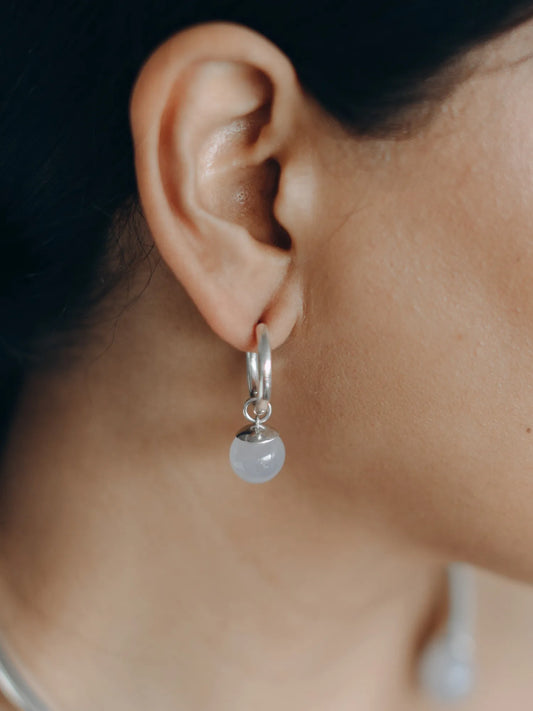Model wearing Maancy interchangeable drop hoop earrings with moonstone sphere, showcasing the elegant profile of sterling silver and natural gemstone combination.