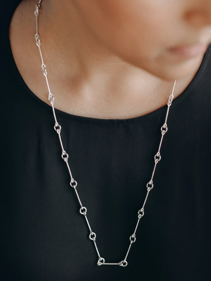 Maancy sophisticated silver infinity chain necklace worn with formal black top, highlighting the elegant minimalist design.