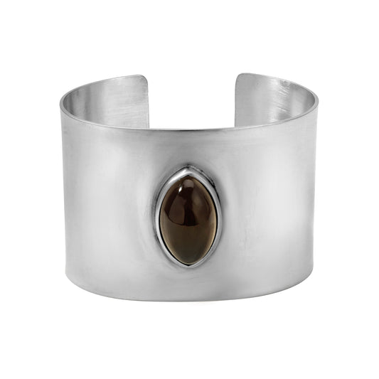 Silver structural cuff bangle with a central brown smoky quartz gemstone on a white background. modernist